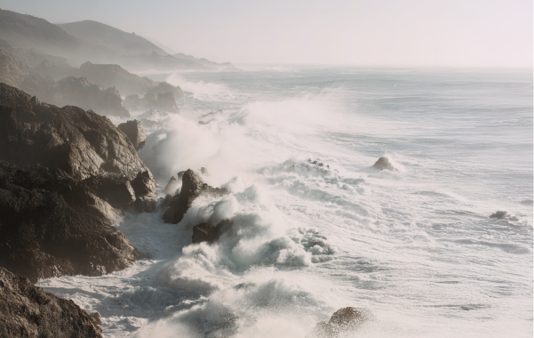 Waves crashing into rocky cliff